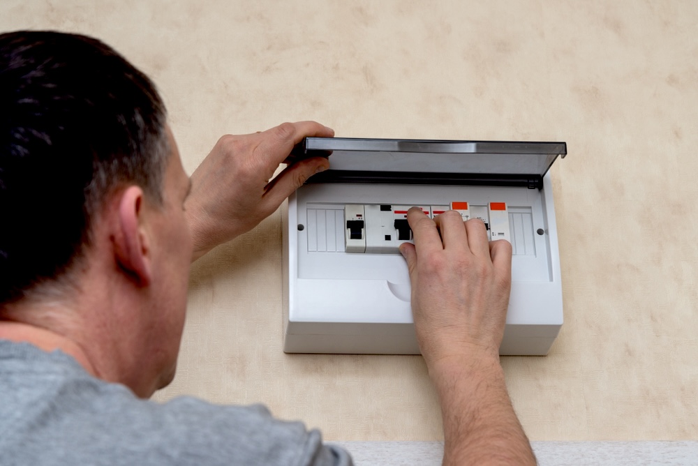Man checking the electrical board panel for problems